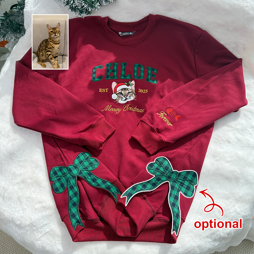 Questa felpa rossa personalizzata presenta un ritratto di animale domestico dai colori vivaci ricamato sul petto, decorato con motivi natalizi e il nome dell'animale, e impreziosito da un delicato fiocco ricamato sull'orlo.