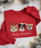 Felpa rossa natalizia con ricami di tre ritratti di cani in stile festivo e scritta “Merry Christmas”, realizzata con dettagliati ricami artigianali.
