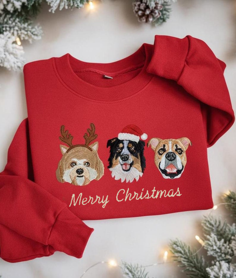 Felpa rossa natalizia con ricami di tre ritratti di cani in stile festivo e scritta “Merry Christmas”, realizzata con dettagliati ricami artigianali.
